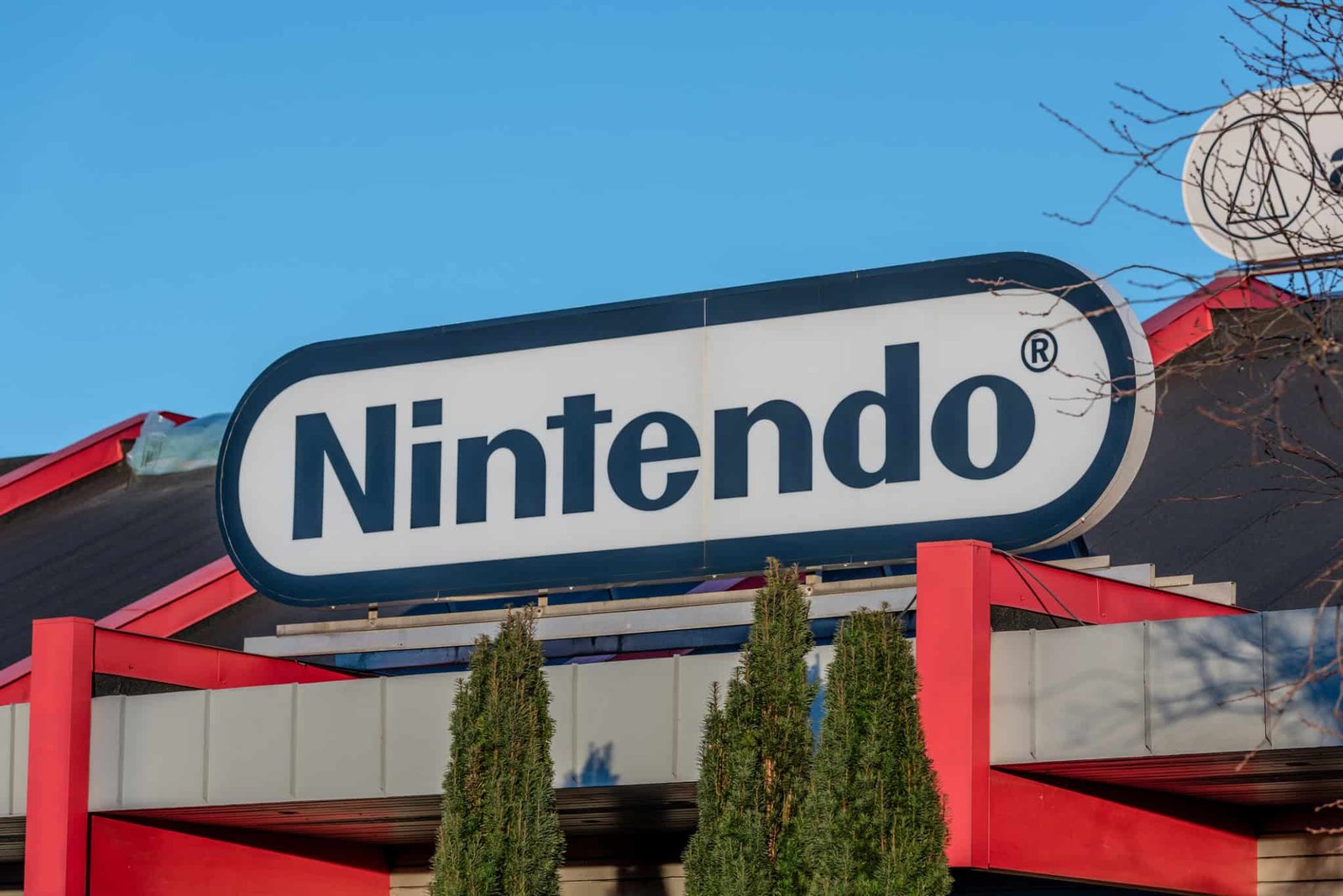 Close-up of a Nintendo Switch console with a retail storefront blurred behind it