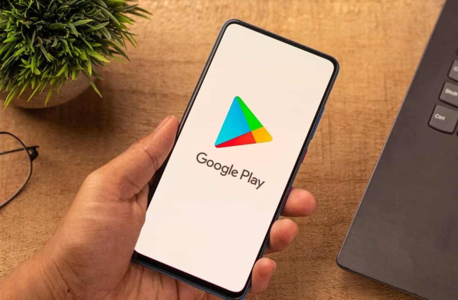 Google Play logo displayed on a smartphone held in a hand