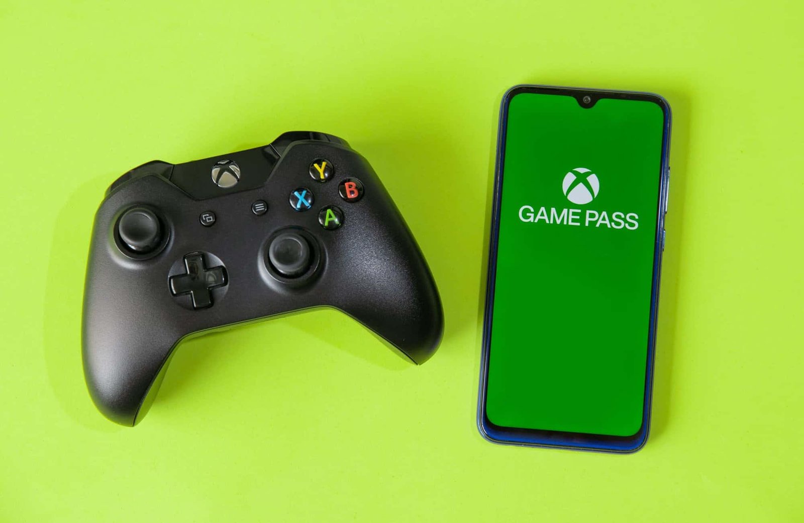 Xbox Game Pass logo displayed on screens with controllers nearby